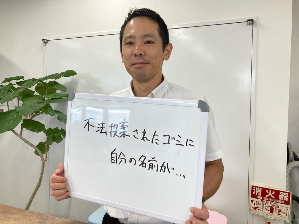 不法投棄の事例について解説し、ホワイトボードを持つ初田理事